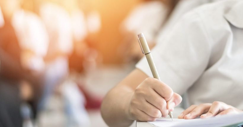 Exam with school student having a educational test, thinking hard, writing answer in classroom for  university education admission and world literacy day concept